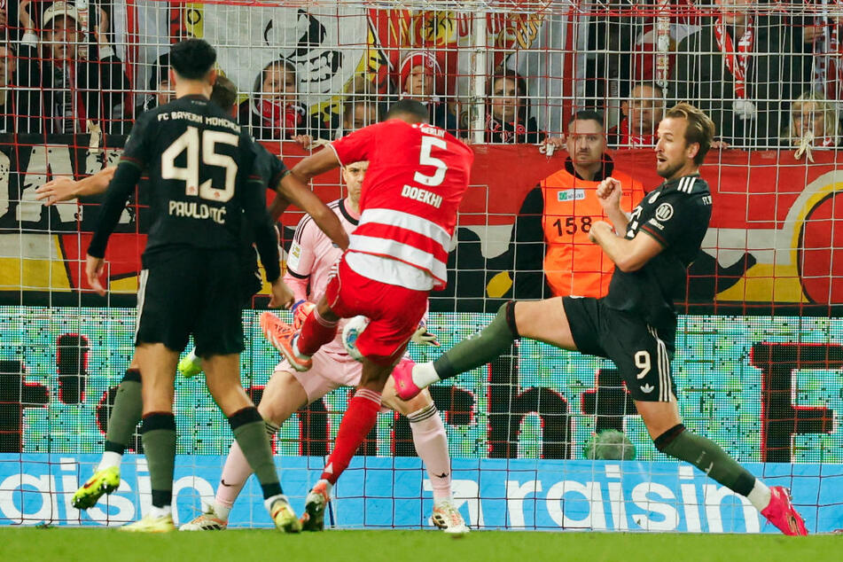 Danilho Doekhi (M.) erzielt seinen zweiten Treffer und nutzt dabei einen Fehler von Harry Kane (r.) aus, der ihm den Ball genau vor die Füße geköpft hat.