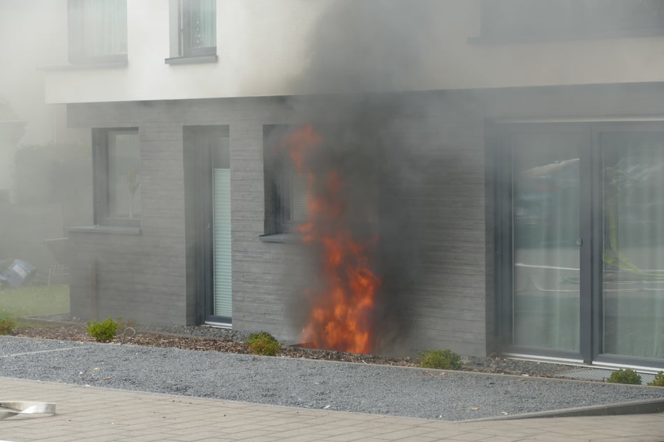 Als die Feuerwehr an dem Mehrfamilienhaus in Hennef ankam, schlugen hohe Flammen aus einem der Kellerfenster.