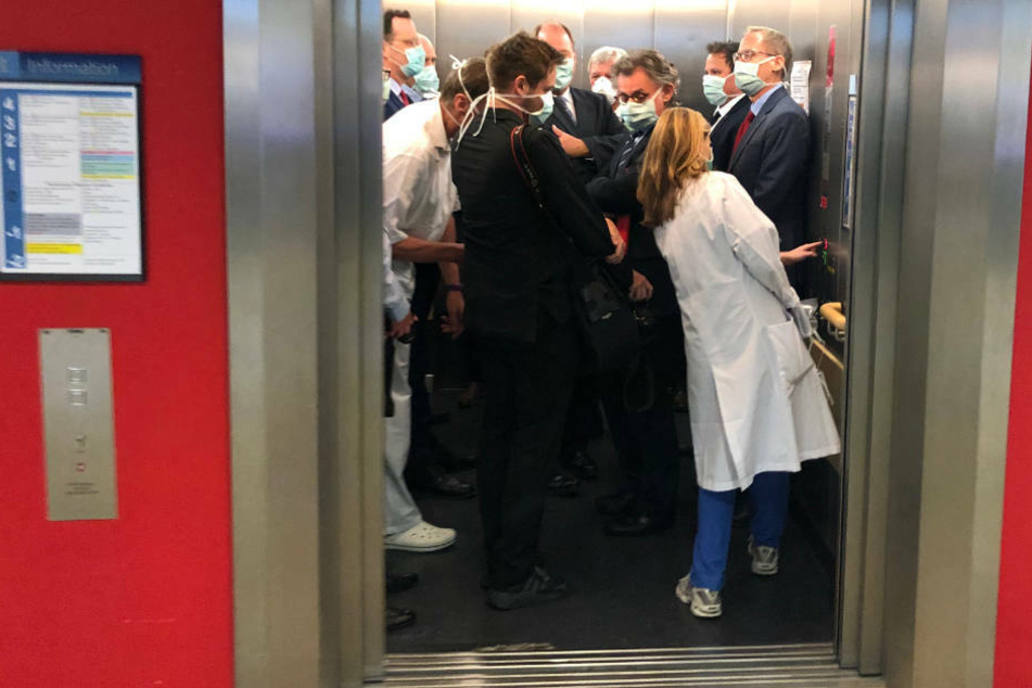 Bei einem Besuch der Uniklinik Gießen drängen sich Bundesgesundheitsminister Jens Spahn (CDU, l), und Hessens Ministerpräsident Volker Bouffier (CDU, M) mit Begleitern in einem Fahrstuhl.
