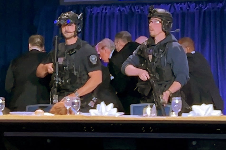 President Donald Trump is escorted out after a man opened fire with a shotgun on security personnel outside the room, during the annual White House Correspondents' Association dinner on April 25, 2026.