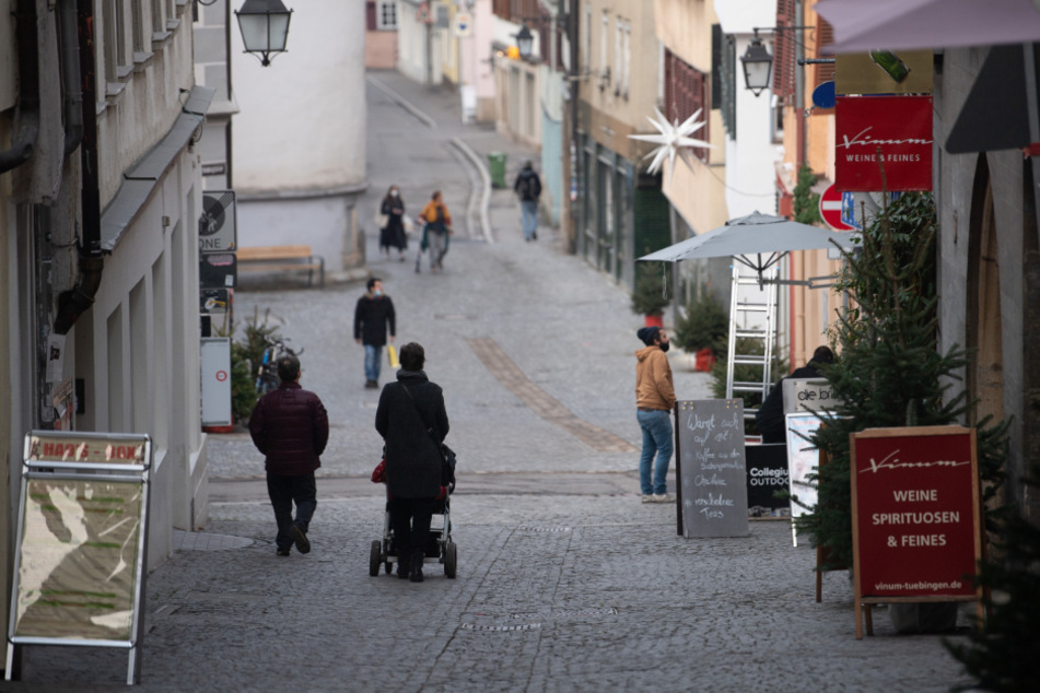 Nur wenige Menschen gehen durch eine Gasse in der Tübinger Innenstadt.