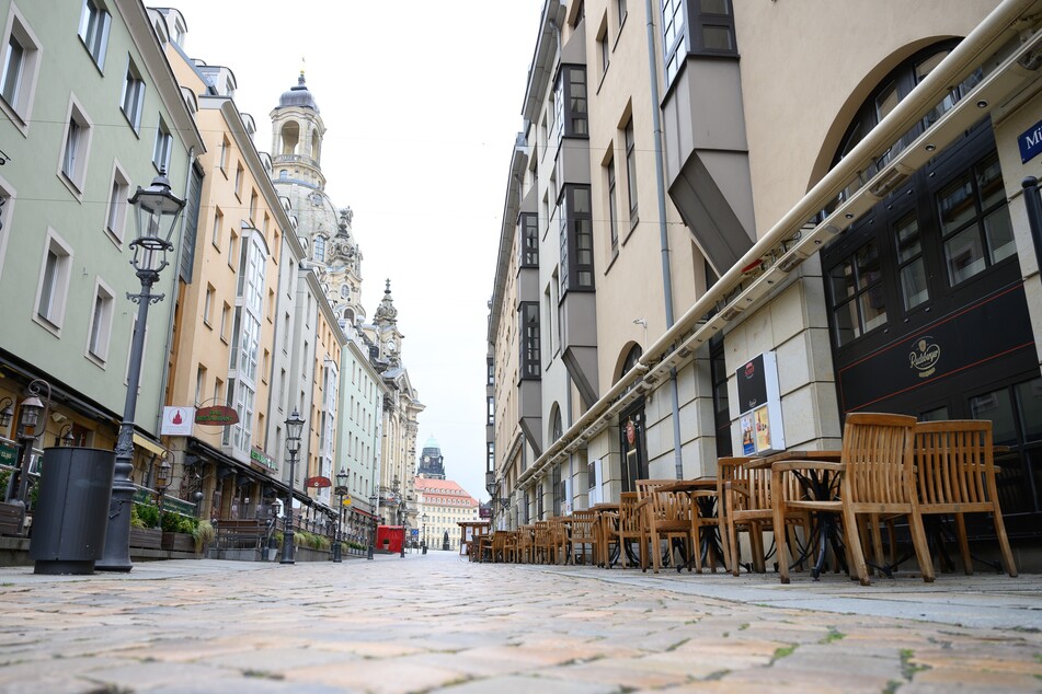 Leere Tische und Stühle stehen vor noch immer geschlossenen Lokalen auf der Münzgasse in Dresden.
