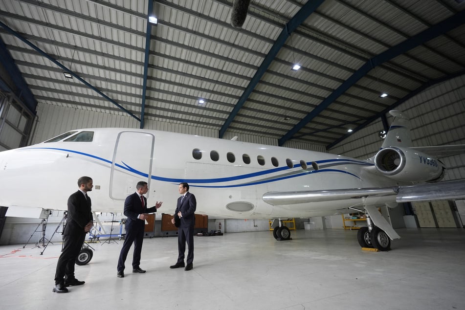 US Secretary of State Marco Rubio listens to Edwin F. Lopez, the attache for DHS Homeland Security Investigations, next to the Venezuelan government airplane that Rubio announced is being seized at La Isabela International Airport in Santo Domingo, Dominican Republic.