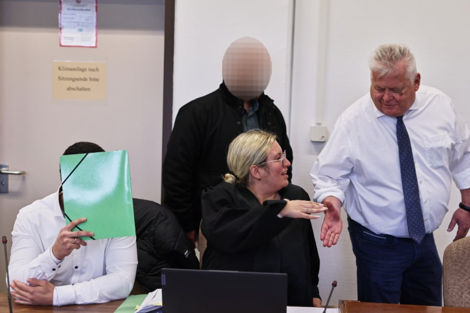 Vor Gericht versteckte sich einer der angeklagten Prügel-Polizisten (l.) hinter einer grünen Aktenmappe.