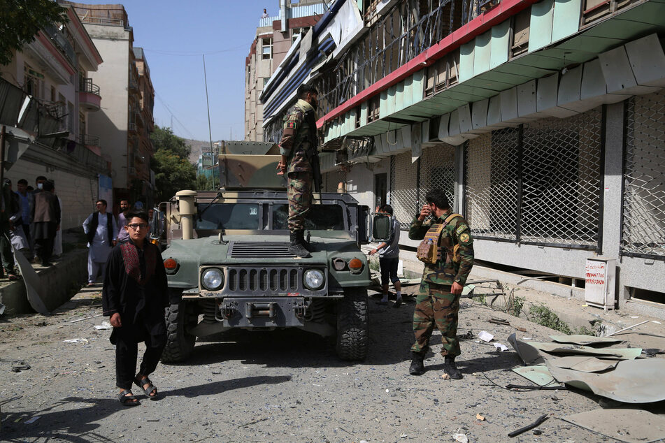 Afghan security force members are seen at the site of a car bomb in Kabul, Afghanistan.