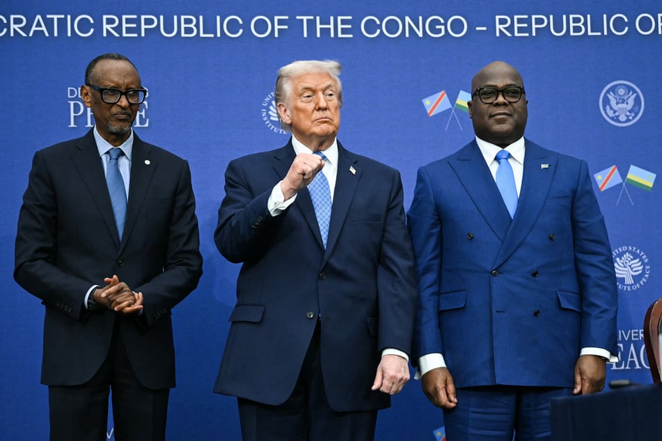 US President Donald Trump (c.) raises his fist as he hosts the signing ceremony of a peace deal with the President of Rwanda Paul Kagame (l.) and the President of the Democratic Republic of the Congo Felix Tshisekedi (r.) in Washington DC on December 4, 2025.
