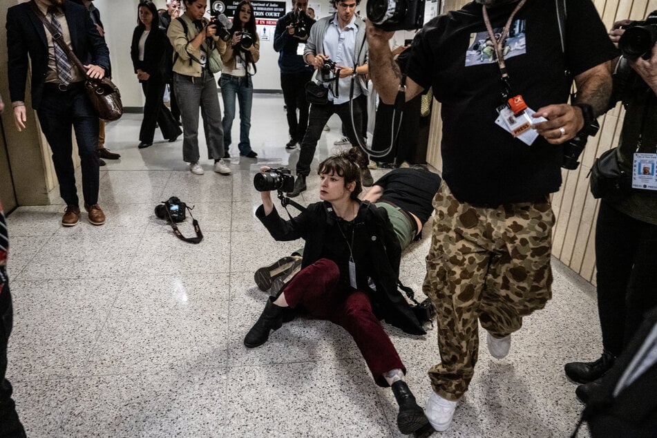 Olga Fedorova, freelance photojournalist, and L. Vural Elibol are thrown to the ground by federal agents at the Jacob K. Javits federal courthouse on September 30, 2025.