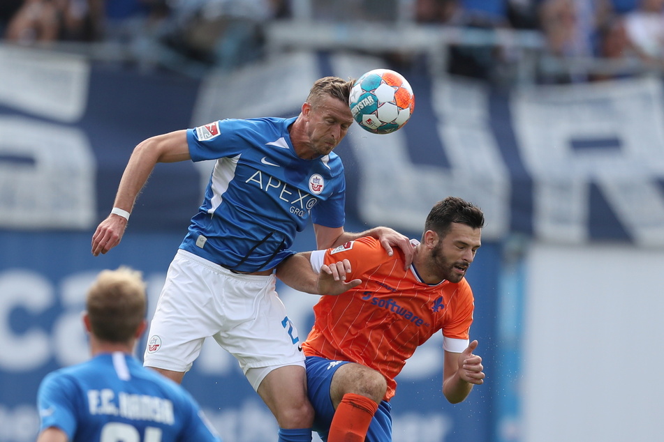 Hansa Rostocks Thomas Meißner (l.) setzt sich im Luftkampf gegen Luca Pfeiffer vom SV Darmstadt 98 durch.