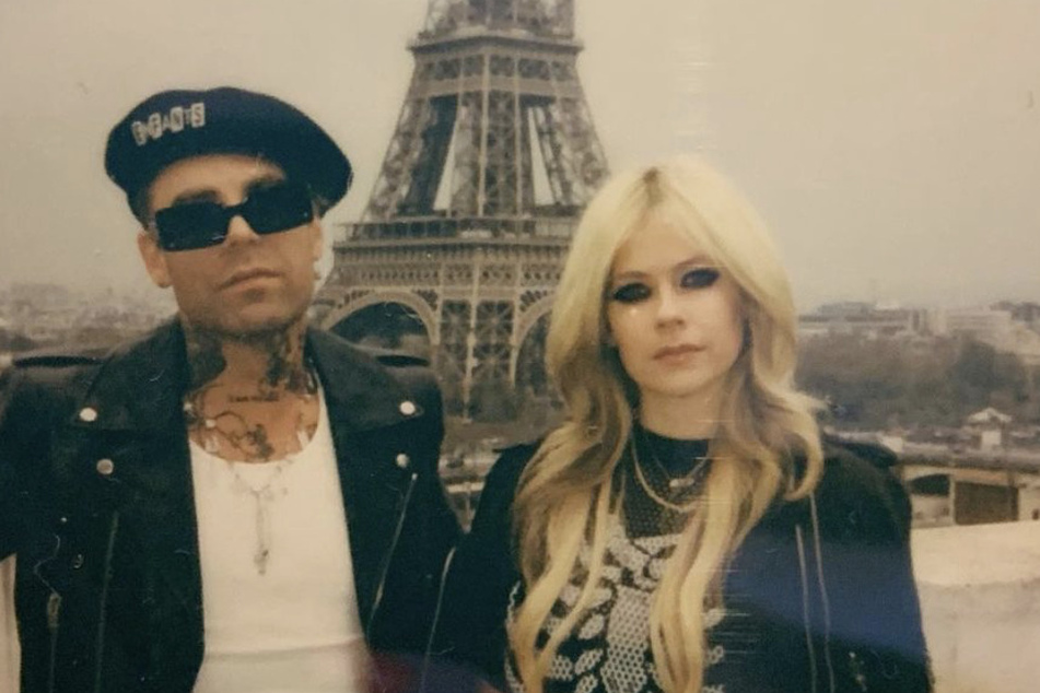 Avril Lavigne (r) and her new fiancé Mod Sun (l) posed by the Eiffel Tower after the Hotel Motel member popped the question during a romantic boat ride on the Seine River.