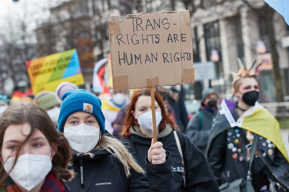 Eine Teilnehmerin hält auf einer Demonstration ein Transparent mit der Aufschrift "Transrigthts are human rights“.