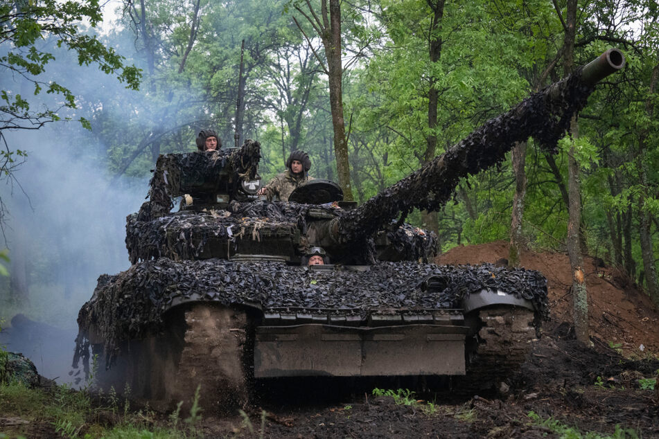 Ukrainische Soldaten fahren mit Panzerfahrzeugen auf einer Straße zu ihren Stellungen in der Nähe von Bachmut in der Region Donezk.