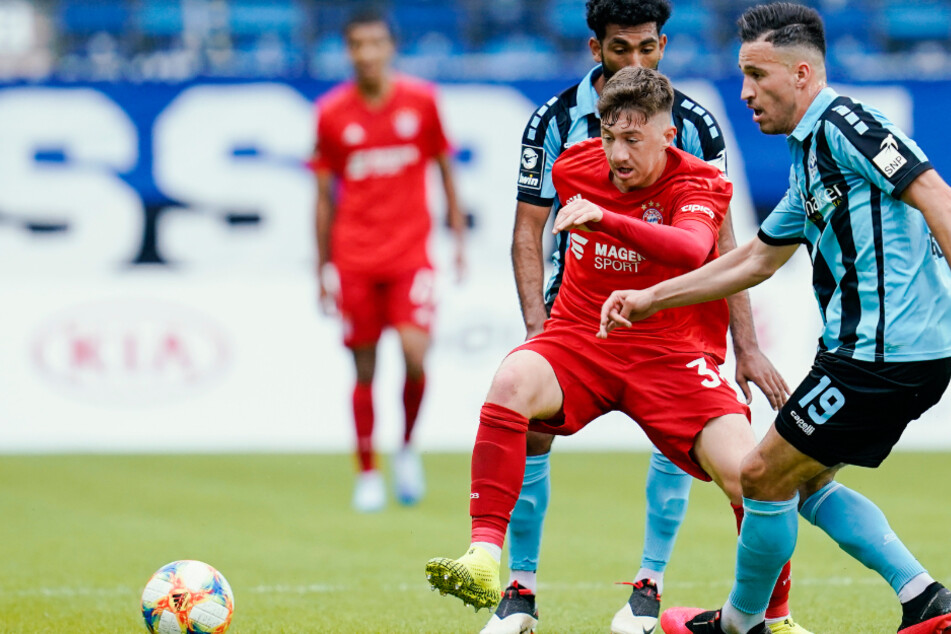 Münchens Angelo Stiller (Vordergrund, rotes Trikot) kämpft mit den Mannheimern Mounir Bouziane und Mohamed Gouaida um den Ball.