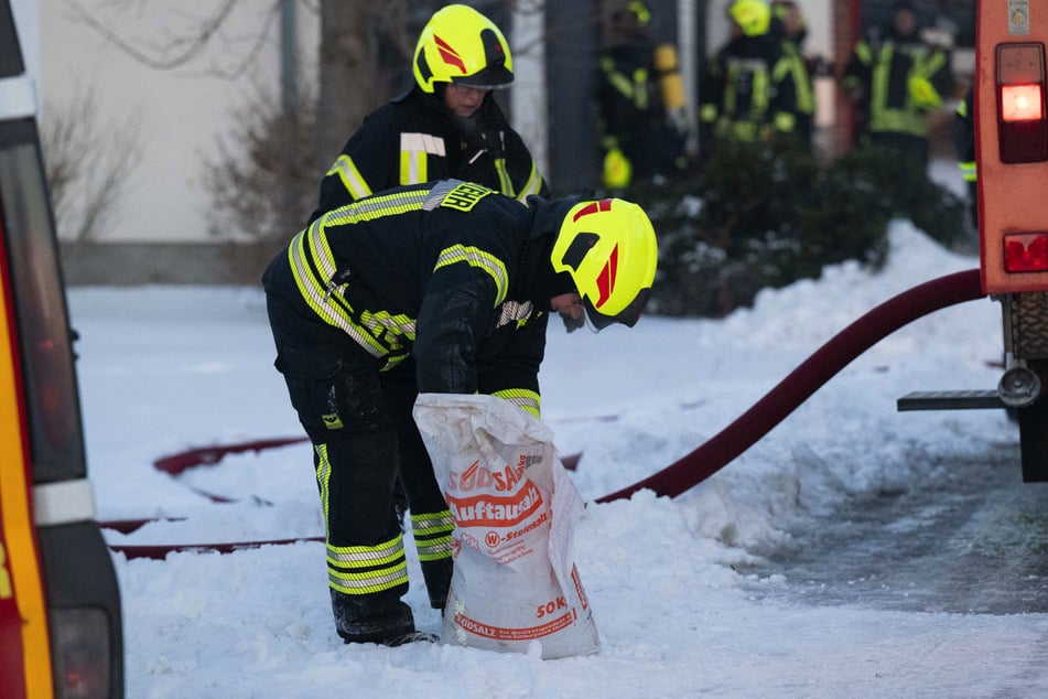 Um die Sicherheit der Einsatzkräfte trotz Glätte zu gewährleisten, streuten Kameradinnen und Kameraden die Einsatzstelle ab.