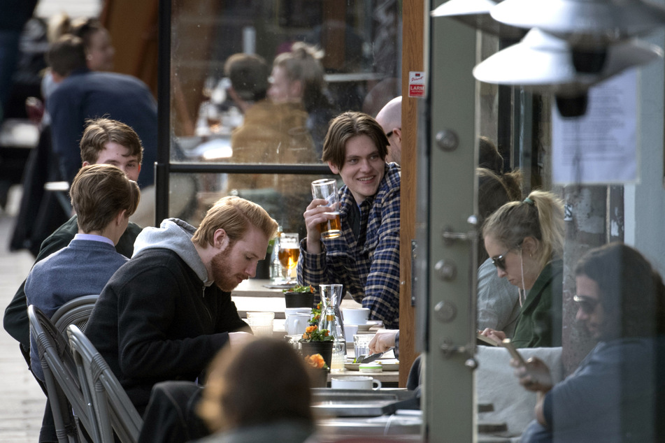 Die Menschen sitzen im Stadtzentrum in Stockholm auf der Terrasse eines Restaurants.