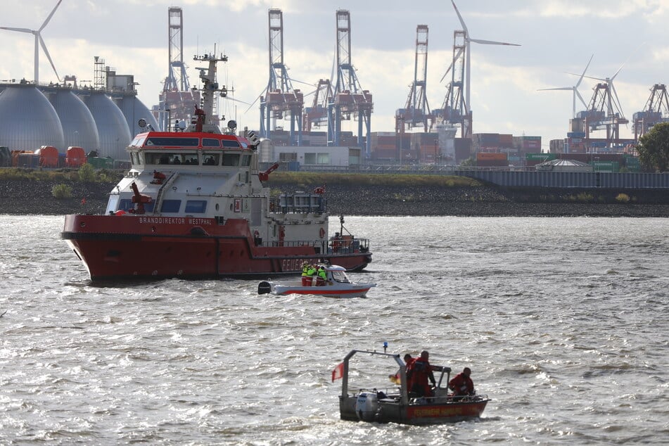 Boote der Feuerwehr und Polizei Hamburg suchen die Elbe ab.