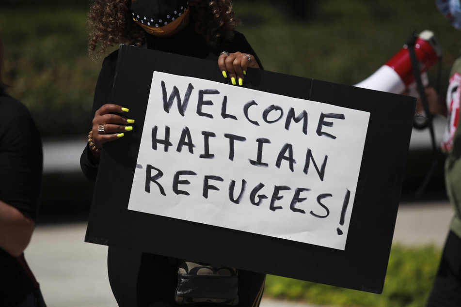 A demonstrator holds a sign reading "Welcome Haitian Refugees!" at a rally in Houston, Texas.
