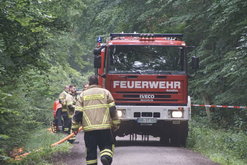 Einsatzkräfte der Feuerwehr gehen zur Unglücksstelle.