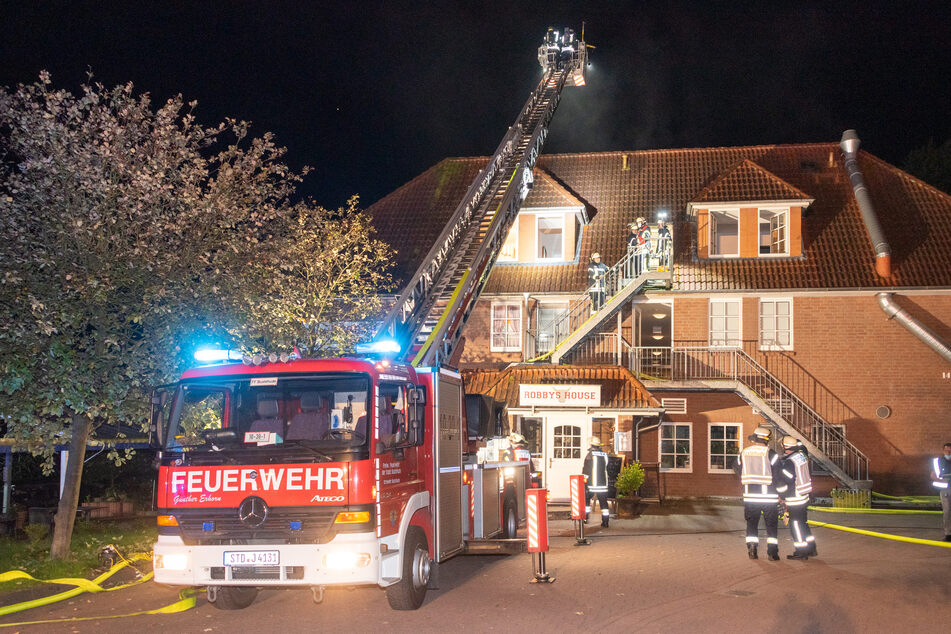 Feuerwehrleute löschen die brennende Wohnung im zweiten Obergeschoss.