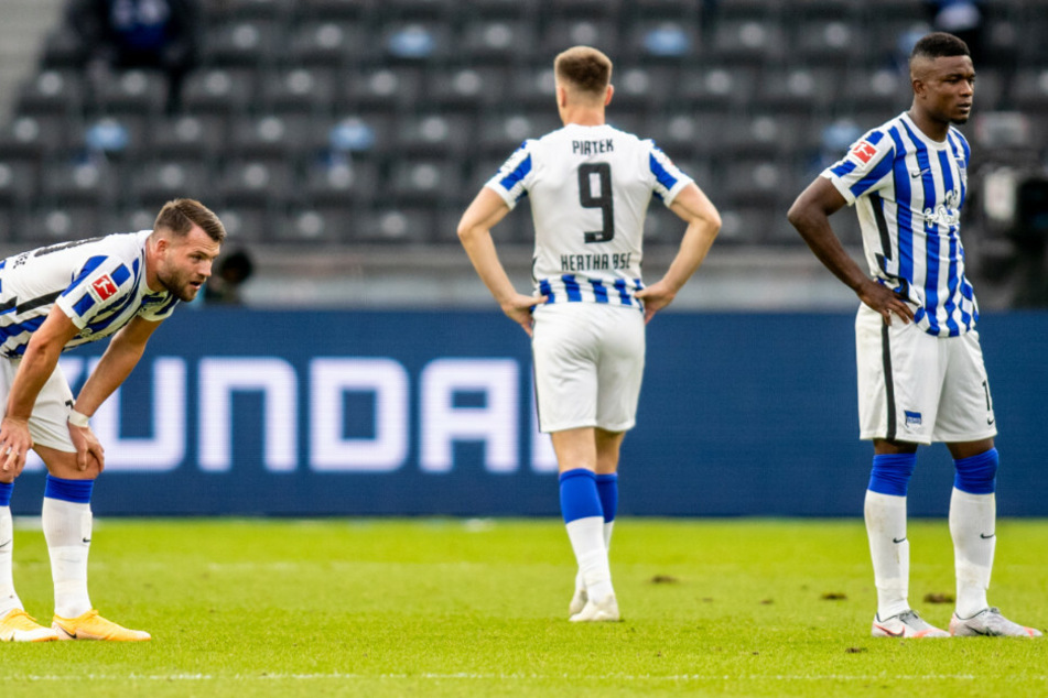 Herthas Eduard Löwen (l.), Krzysztof Piatek und Jhon Cordoba (r.) von Hertha BSC stehen nach der Niederlage enttäuscht auf dem Spielfeld.