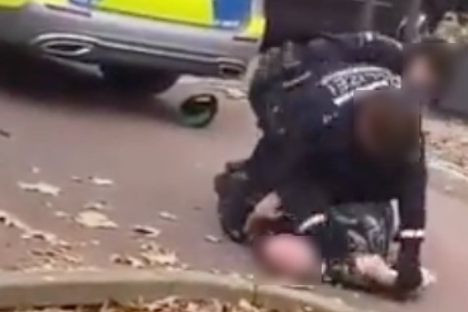 "Lass' mich los, Du Ar***!": Mann liegt am Boden, Polizist schlägt zu