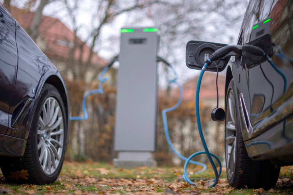 Zwei Elektroautos werden an einer öffentlichen Ladesäule geladen.
