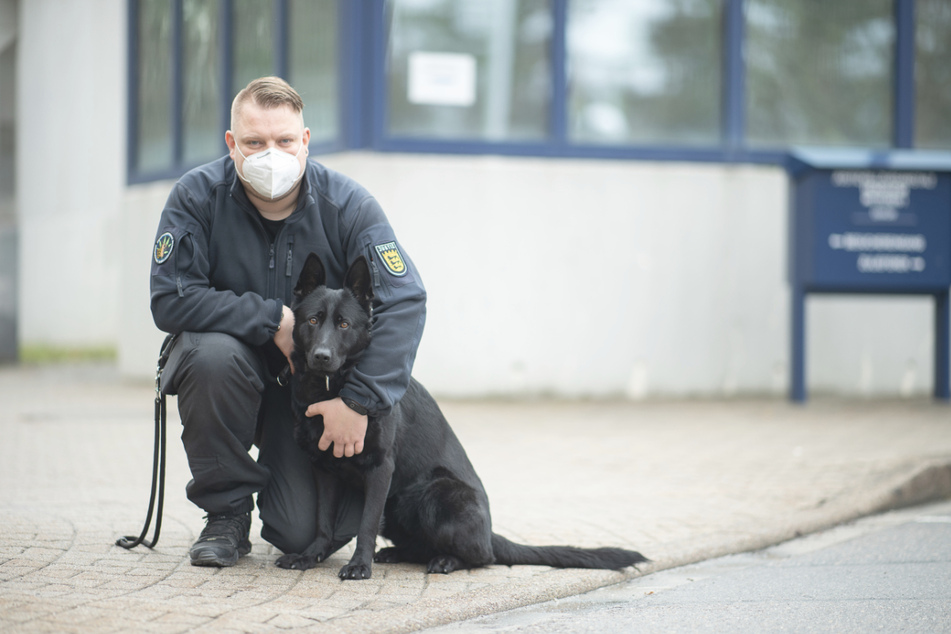 Diensthundeführer Florian Weiner steht mit seiner schwarzen Schäferhündin Emily vor dem Eingang des Gefängnisses in Heimsheim.