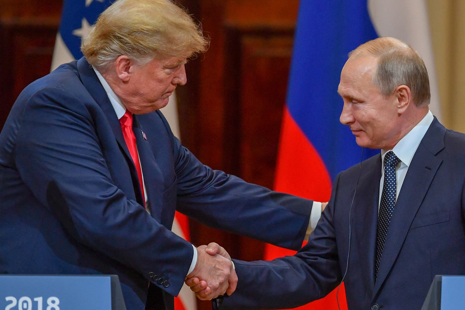 Then-US President Donald Trump (l.) and Russian President Vladimir Putin (r.) shake hands before attending a joint press conference following a meeting at the Presidential Palace in Helsinki on July 16, 2018.