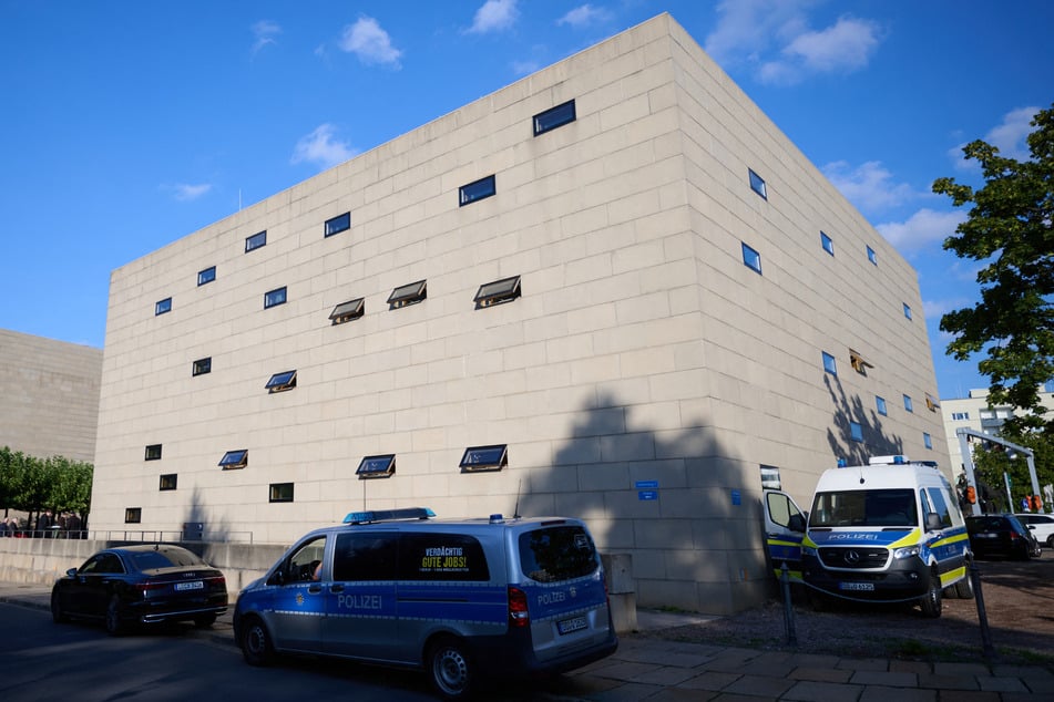 Polizeifahrzeuge stehen vor Beginn der Wiedereröffnung der Dresdner Synagoge vor dem Gebäude.