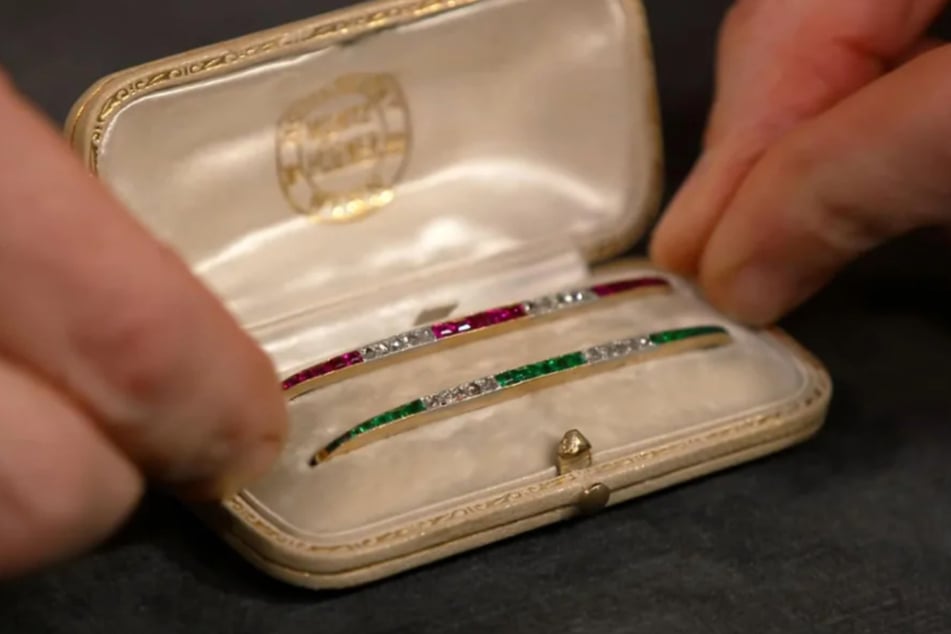Die zwei Stabbroschen sind mit Rubinen und Smaragden sowie 20 kleinen Diamantrosen besetzt. Schätzpreis: bis zu 1500 Euro.