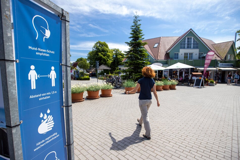 Hinweisschilder der Kurverwaltung zu den als Corona-Schutzmaßnahme vorgeschriebenen Sicherheitsabständen und anderen Empfehlungen hängen an der Strandpromenade in Zingst.
