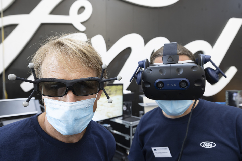 Zwei Ford Mitarbeiter präsentieren auf der Technologie-Ausstellung "Manufacturing TechDays" im Kölner Ford Werk eine Virtual-Reality-Anwendung.