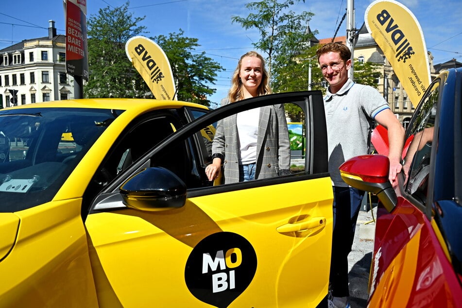 Freuen sich über den neuen MOBIpunkt, an dem auch E-Autos zur Ausleihe angeboten werden: "teilAuto"-Regionalleiter Marcus Buchfeld (31) und Kundin Sarah Ott (27).