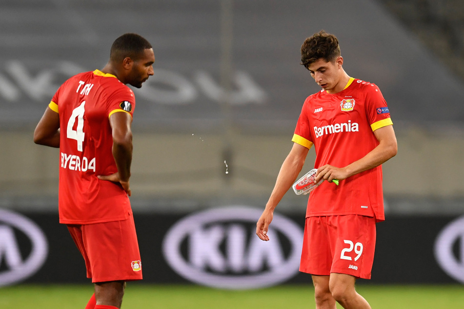 Leverkusens Jonathan Tah (l.) und Kai Havertz stehen nach Abpfiff enttäuscht auf dem Platz.