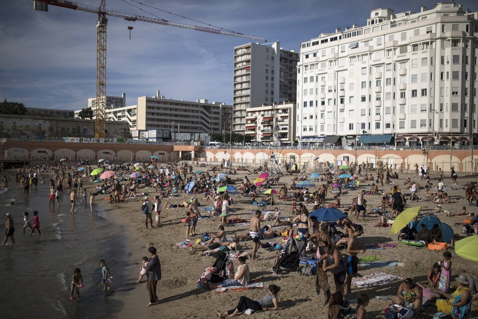 Strandbesucher genießen die Sonne am Plage des Catalans.