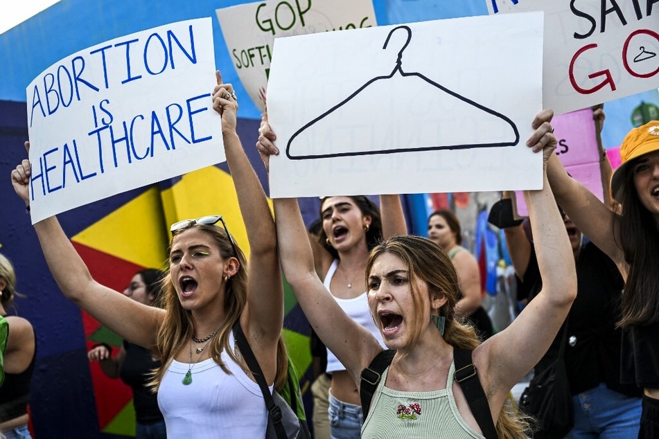 Abortion rights activists hold signs reading "Abortion is Healthcare" as they rally in Florida after the overturning of Roe v. Wade.