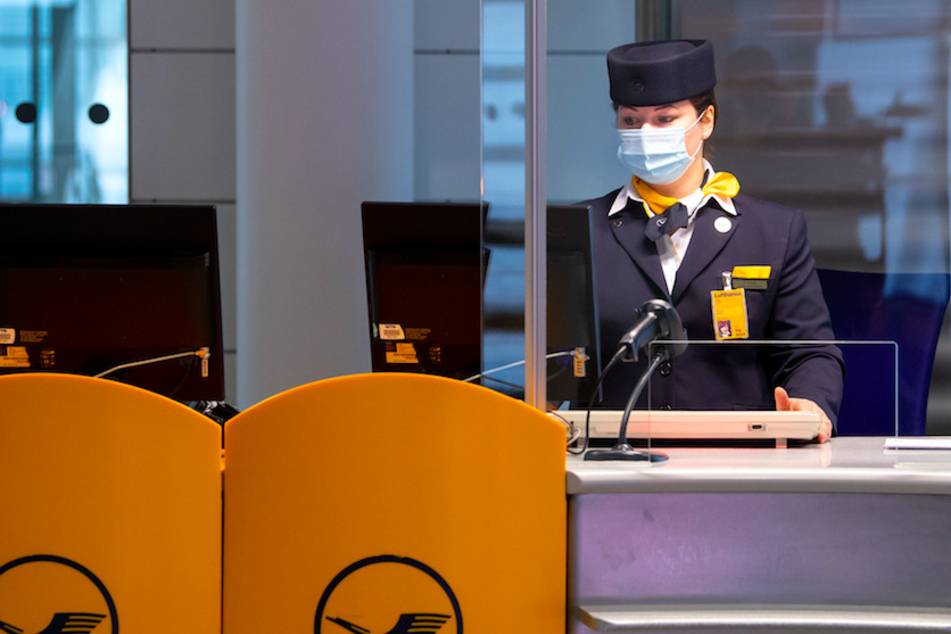 Eine Mitarbeiterin von Lufthansa bereitet an einem Gate am Flughafen München das Boarding für einen Flug vor.