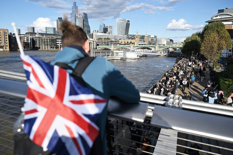 Ein Brite schaut auf die Warteschlange, wo Tausende auch mal mehr als 24 Stunden verbringen, um die Queen noch einmal zu sehen.