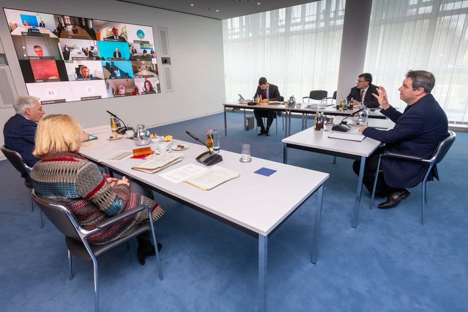 Markus Söder (r, CSU, 53), Ministerpräsident von Bayern, nimmt an einer Videokonferenz des Katastrophenstabs der Staatsregierung teil.