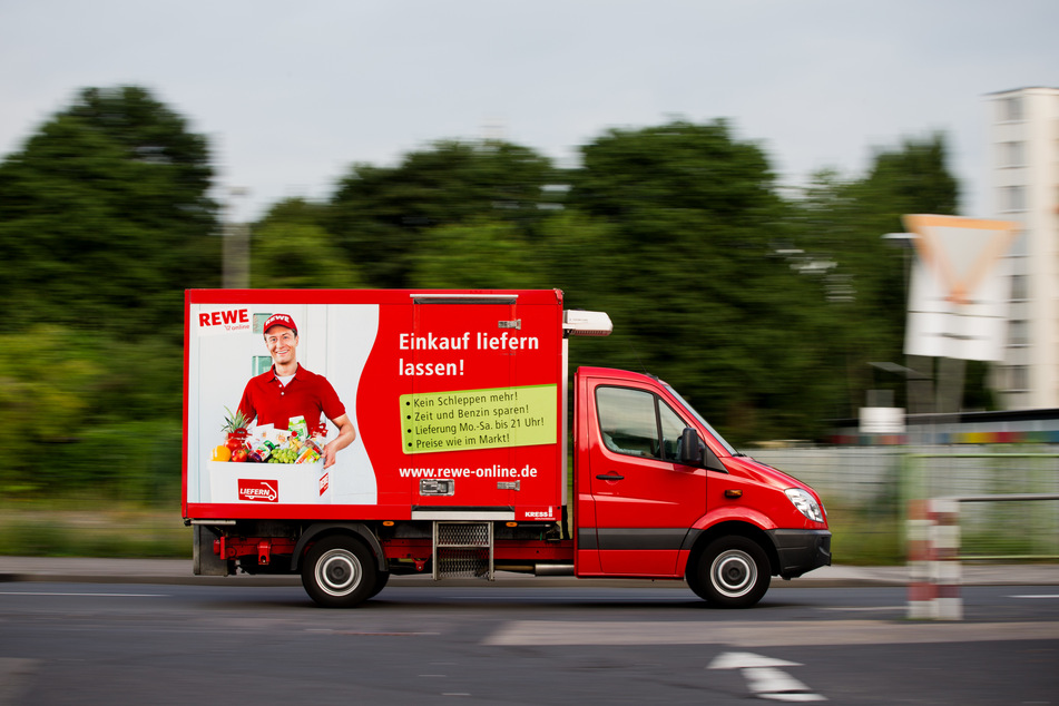 Ein Lieferwagen von Rewe Online fährt am auf einer Straße.