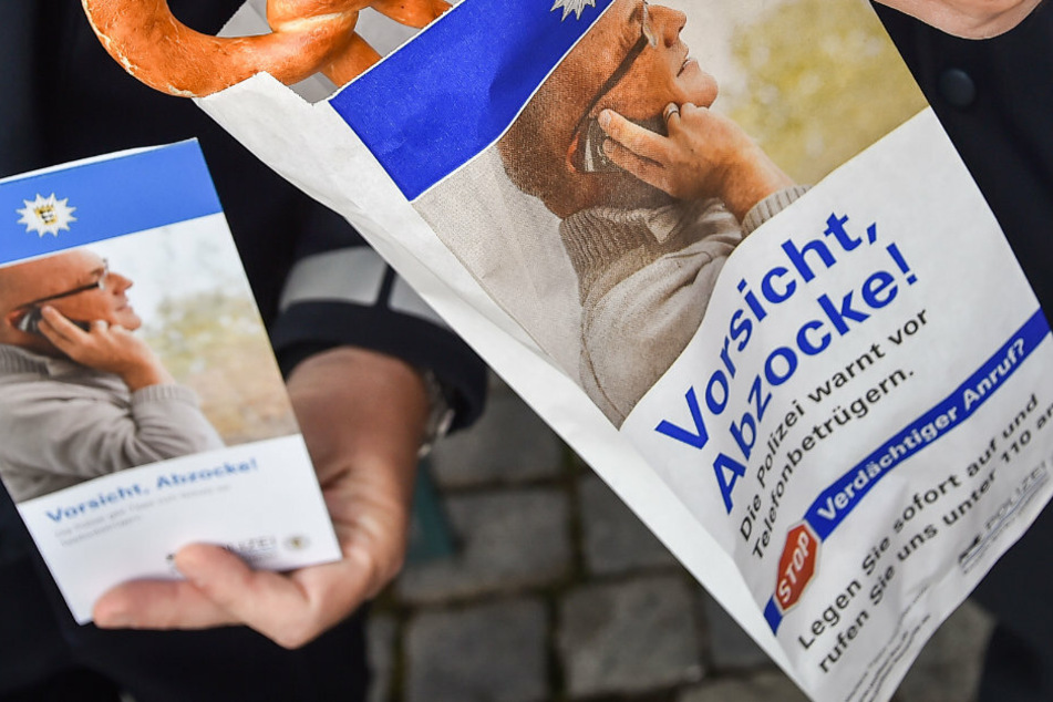 Polizisten machen mit einer Aktion auf Telefonbetrüger aufmerksam. (Symbolbild)
