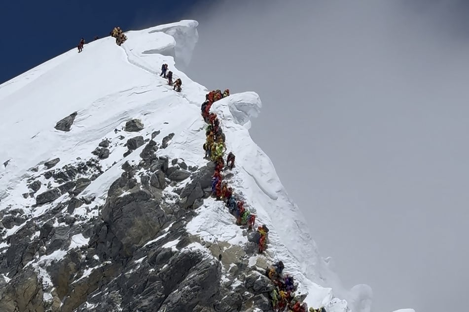 This photograph, taken on May 20, 2026, shows mountaineers climbing a slope lined up during their ascent from the Hillary Step to summit Mount Everest in Nepal.