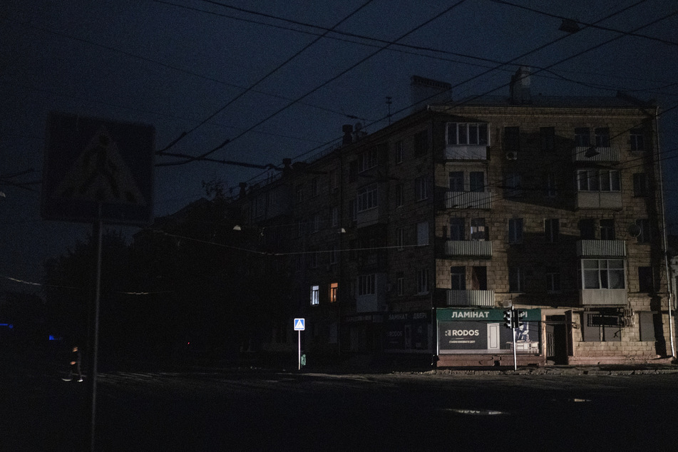 Ein Mann überquert eine dunkle Straße in Charkiw.