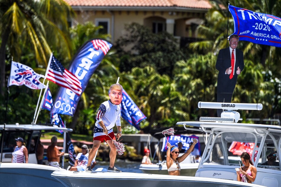 A man donning a mask of Donald Trump dances as he participates in a boat rally to celebrate Trump's birthday in Fort Lauderdale, Florida, on June 14, 2020.