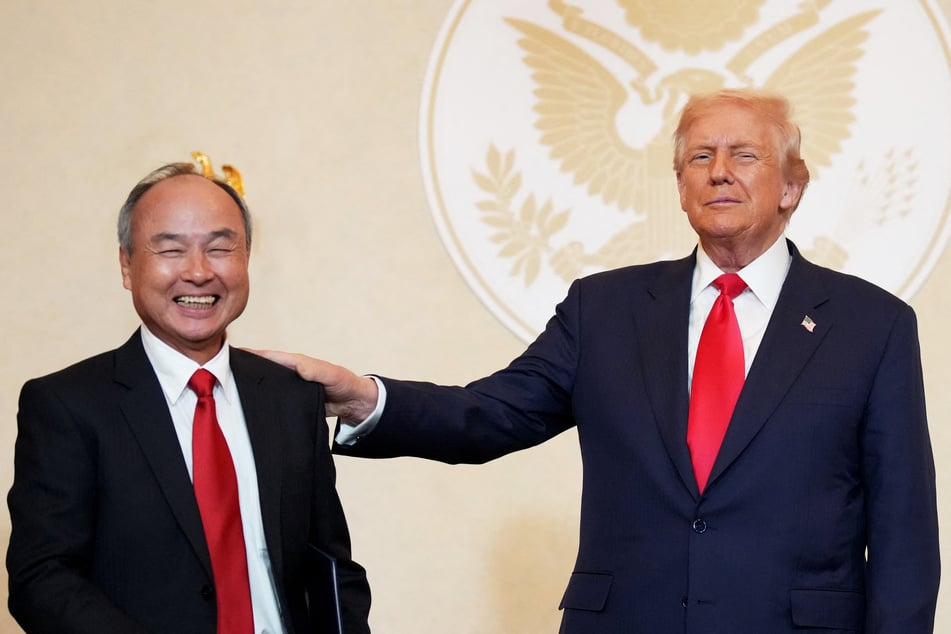 Softbank CEO Masayoshi Son (l.) and President Donald Trump react after the signing of memorandums of understanding during a meeting with business leaders at the US Ambassador's Residence in Tokyo, Japan, on October 28, 2025.