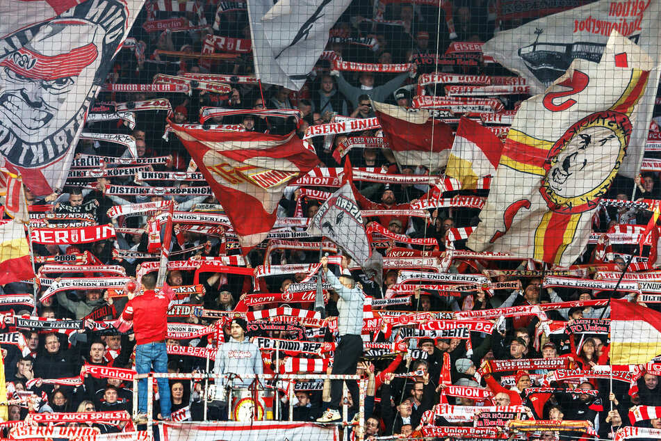 Fans von Union Berlin feuern ihr Team mit Schals an.