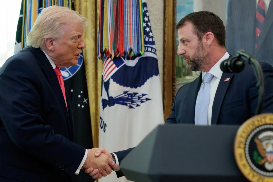 President Donald Trump shakes hands with Markwayne Mullin after he was sworn in as Department of Homeland Security Secretary, at the White House on March 24, 2026.