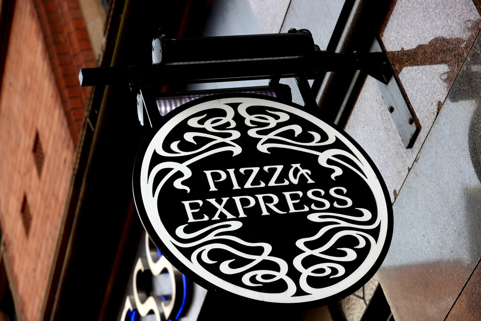 Ein Schild mit dem Logo von Pizza-Express hängt an einem Restaurant.