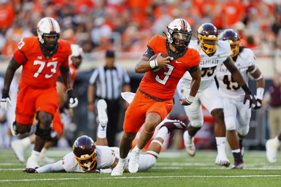 Quarterback Spencer Sanders #3 of the Oklahoma State Cowboys breaks free for a 23-yard touchdown run against the Central Michigan Chippewas.