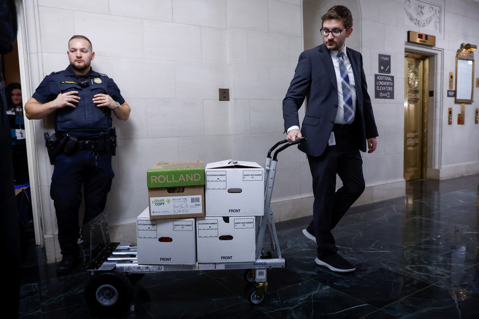A House Ways and Means Committee staff member transports boxes of documents after a meeting to discuss former President Donald Trump's tax returns.