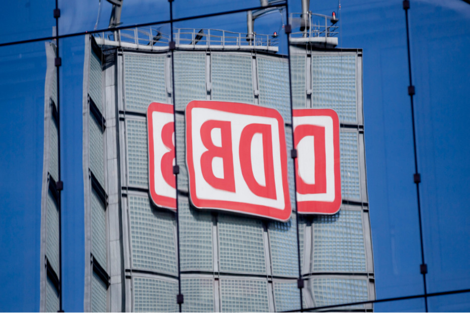 Das Logo der Deutschen Bahn AG (DB) am Berliner Hauptbahnhof spiegelt sich in einer Gebäudefassade.